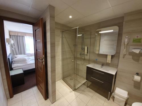 a bathroom with a shower and a toilet and a sink at Toila Spa Hotel in Toila