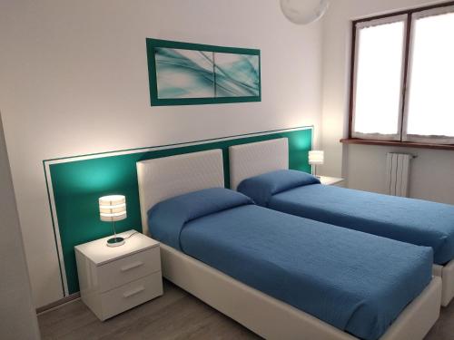 een slaapkamer met 2 bedden met blauwe lakens bij Villa Fiori in Malcesine
