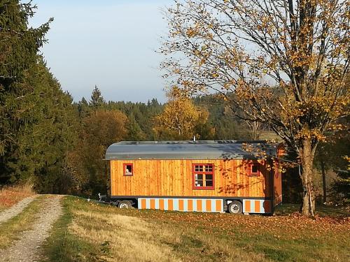 une petite maison assise sur le côté d'une route dans l'établissement Benno der Zirkuswagen, à Tettau