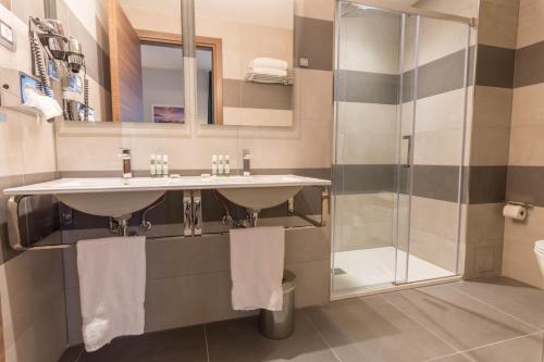 a bathroom with two sinks and a shower at Hôtel Nice Azur Riviera in Nice