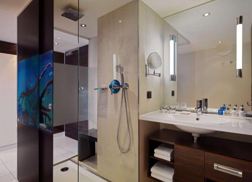 a bathroom with a shower and a sink at Radisson Blu Hotel Leipzig in Leipzig