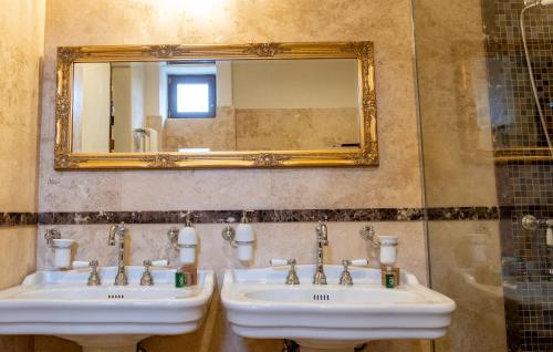 a bathroom with two sinks and a mirror at The Throne - M Museum Hotel in Sighişoara