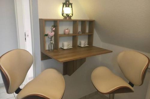 two chairs and a shelf on a wall with a table at Ferienwohnung Meeresbrise in Aventoft