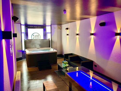 Habitación con cama, mesa y luces púrpuras. en Salt-Rock, en Blackpool