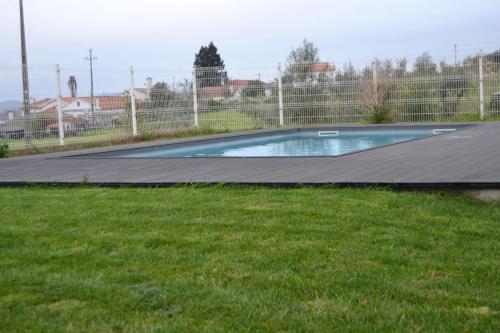 an empty swimming pool in a yard with grass at Casa do Mouro in Lousã