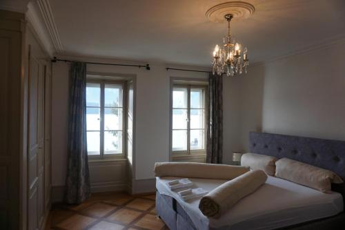 a living room with a couch and a chandelier at Villa Pochon in Gunten