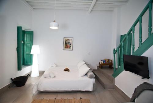 a living room with a white couch and a tv at Scaleri Port Home in Kalymnos