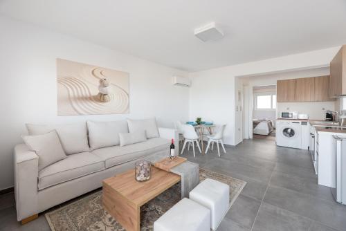 a living room with a white couch and a table at COSTA VASIA Seaside Suites and Apartments in Vrahati