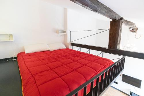 een slaapkamer met een rood dekbed op een bed bij HouSmart Pratello 48 in Bologna