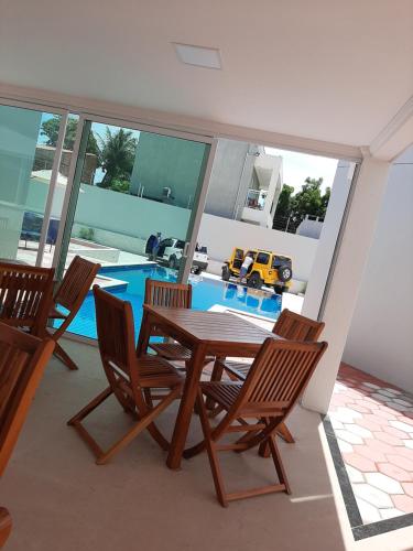 uma sala de jantar com mesa e cadeiras e uma piscina em Terraço Hotel em Lagoinha