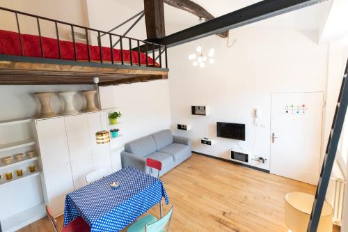 een woonkamer met een hoogslaper en een bank bij HouSmart Pratello 48 in Bologna