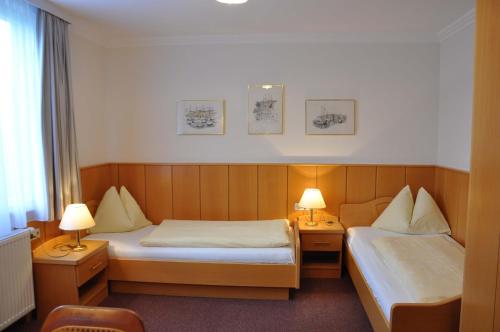 a hotel room with two beds and two lamps at Appartements Irene in Sankt Kanzian