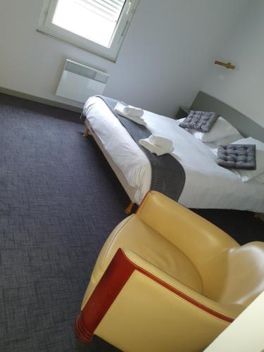 a hotel room with two beds and a yellow chair at Hôtel du Parc in Salies-du-Salat