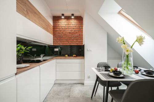 a kitchen with white cabinets and a table with flowers at Absyntapart - Bulwar Staromiejski in Wrocław