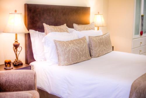 a bedroom with a large white bed with pillows at Anchor's Rest Guesthouse and Self Catering in Durban