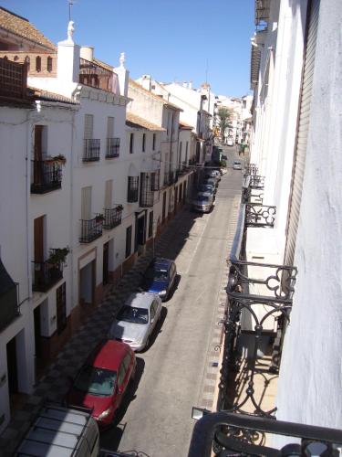 a street with cars parked on the side of a building at Hostal Durán in Alora