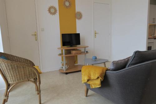 un salon avec un canapé, des chaises et une télévision dans l'établissement Appartement avec superbe VUE MER à TREGASTEL - Ref 6, à Trégastel