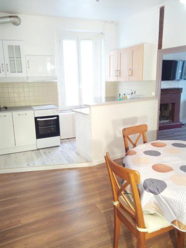 une cuisine avec une table et des placards blancs dans l'établissement Appartement 2 chambres 52 m2 centre ville, à Vendôme