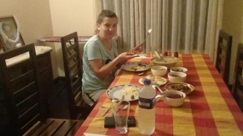 a man sitting at a table with a plate of food at Lake Island Home Stay in Dambulla