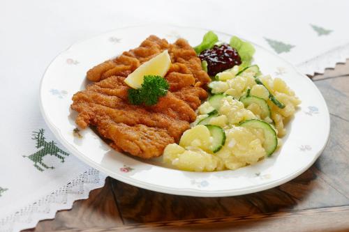 a plate of food with chicken and vegetables on a table at Gasthof Löwen by Hotel Montafoner Hof in Schruns-Tschagguns