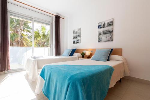 1 dormitorio con 2 camas y ventana grande en Saval Spa Aqquaria Family Complex, en Salou