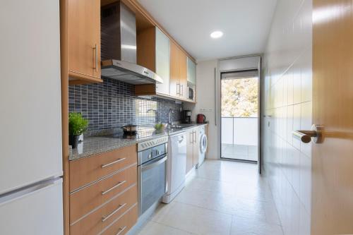 a large kitchen with wooden cabinets and appliances at Saval Spa Aqquaria Family Complex in Salou