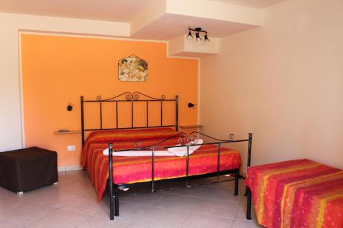 1 dormitorio con 2 camas y pared de color naranja en Villa Mozia, en Marsala