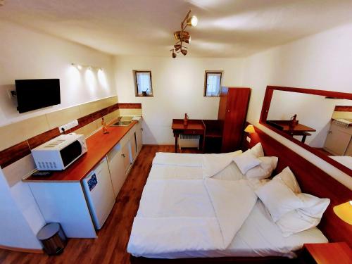 una camera con letto e una cucina con forno a microonde di Kis-Tisza Apartmanházak Tokaj- hegyalja a Tiszaladány