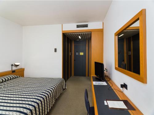 a bedroom with a bed and a desk and a mirror at Grand Hotel Tiziano E Dei Congressi in Lecce