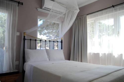 una camera da letto con un grande letto bianco e una finestra di Sklipi Home a Ermoupoli