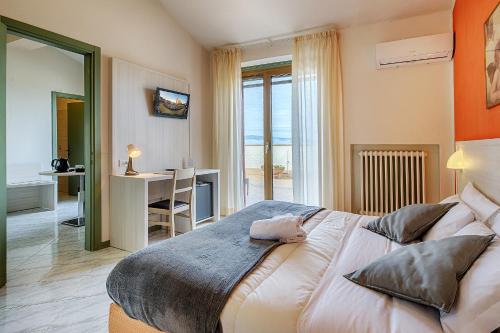 a bedroom with a large bed and a large window at Hotel Castello in Sovicille