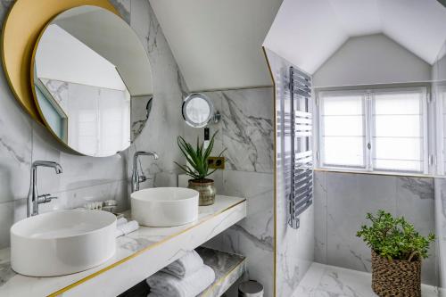 a bathroom with two sinks and a mirror at Maison Albar Hotels - Le Vendome in Paris