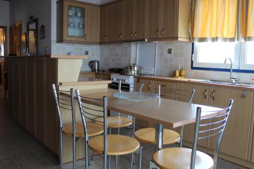 a kitchen with a wooden table and chairs at Balcony of Koroni in Koroni