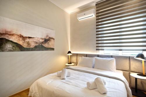 een slaapkamer met een bed en een schilderij aan de muur bij The Flirty Athens apartment in Athene
