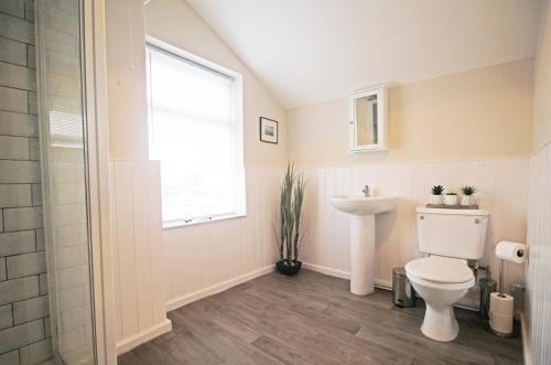 a bathroom with a toilet and a sink and a window at Panton Road - Modern Classic Terrace in Chester
