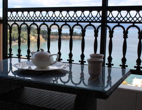 a table with a tea pot and a cup on a balcony at Balcony of Koroni in Koroni