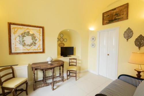 a living room with a table and chairs and a tv at The Tsitouras Collection in Firostefani