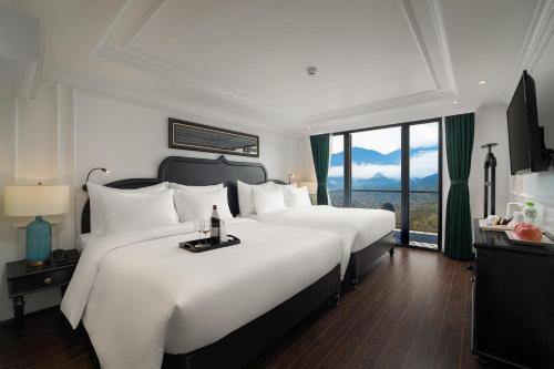 um quarto de hotel com duas camas e uma grande janela em My Gallery Boutique Hotel & Spa em Sapa