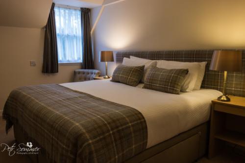 a neatly made bed in a hotel room at The Haven Guest House in Plockton