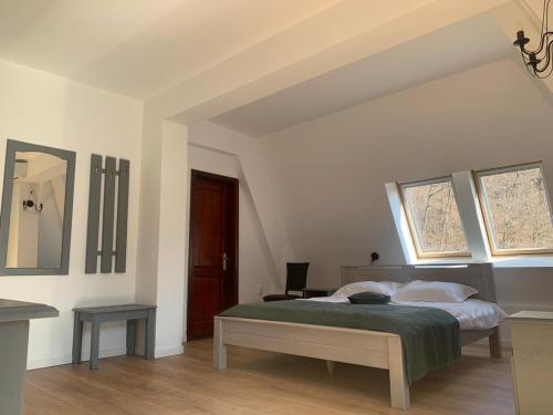 a white bedroom with a bed and a window at Pension Casa Vanatorilor in Băile Olăneşti