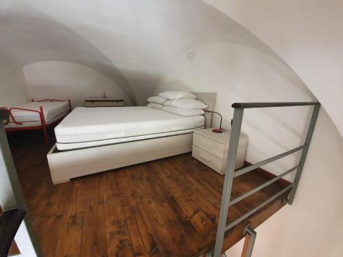 a bedroom with a white bed and a ladder at Il Borgo Apartment in Gaeta