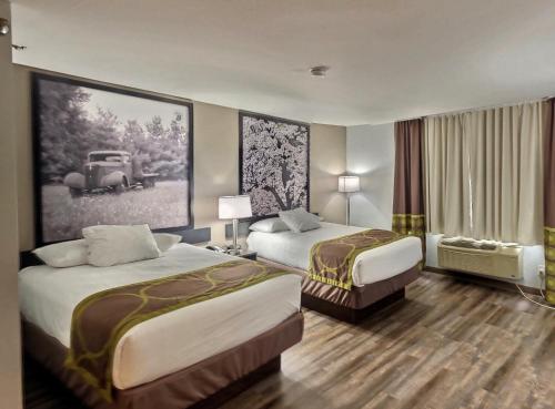 una habitación de hotel con 2 camas y una foto de un coche en Super 8 by Wyndham Georgetown en Georgetown