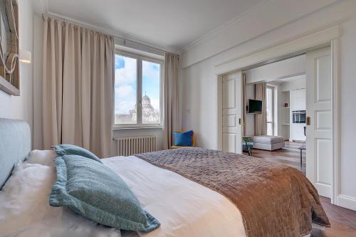 a bedroom with a large bed with a large window at Vilnius Apartments & Suites - Gedimino avenue in Vilnius