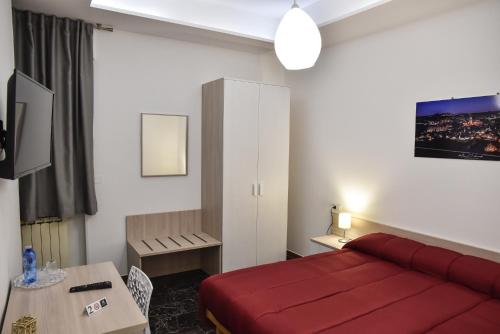 a hotel room with a red bed and a table at Ripahome B&B in Ripalimosani