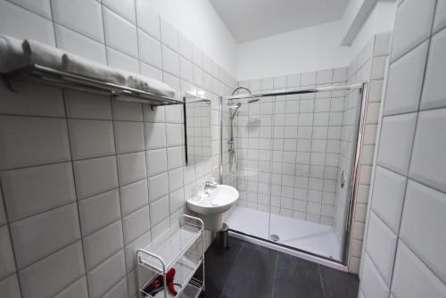 a white tiled bathroom with a sink and a shower at Ripahome B&B in Ripalimosani