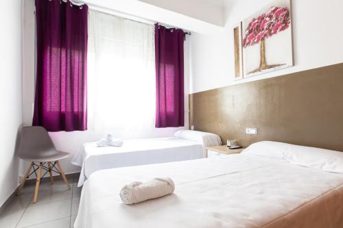 a hotel room with two beds and a window at Pensión Galicia in Canovellas