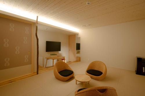a living room with two chairs and a television at so, KANAZAWA in Kanazawa