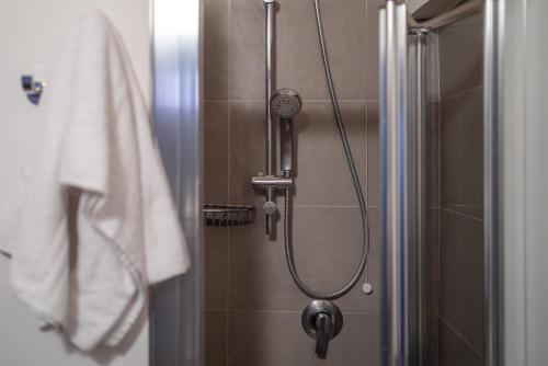 a shower with a shower head in a bathroom at LUOGO COMUNE Ostello in Brescia