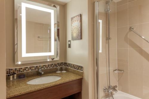 a bathroom with a sink, mirror and bath tub at Slaley Hall Hotel, Spa & Golf Resort in Slaley