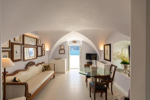 a living room with a couch and a table at The Tsitouras Collection in Firostefani